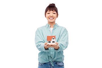 Image showing smiling asian woman holding house model