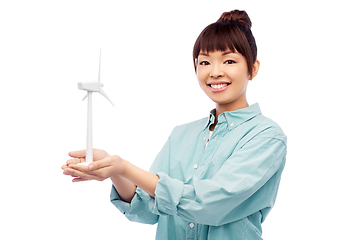 Image showing smiling young asian woman with toy wind turbine