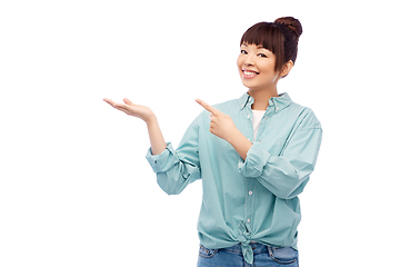 Image showing happy asian woman holding something on hand