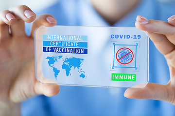 Image showing hand with certificate of vaccination on smartphone