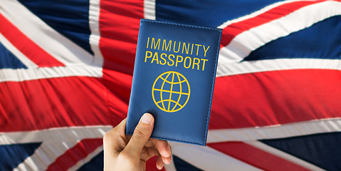 Image showing hand holding immunity passport over british flag