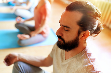 Image showing man with group of people meditating at yoga studio