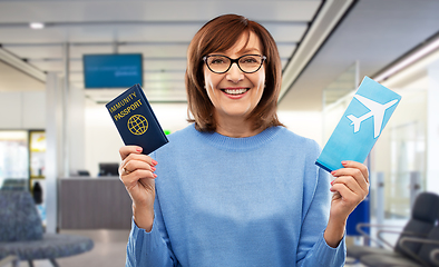 Image showing senior woman with immunity passport and air ticket