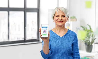 Image showing old woman with certificate of vaccination on phone