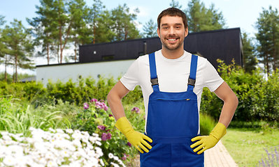 Image showing happy male worker or cleaner in gloves at garden