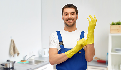 Image showing happy male worker or cleaner in gloves at kitchen