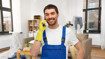 Image showing male worker or cleaner calling on phone at home