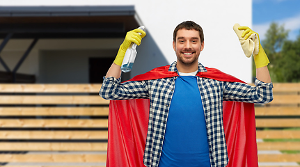 Image showing smiling man in superhero cape with rag and cleaner