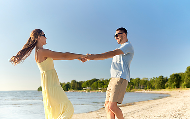 Image showing happy couple holding hands on summer beach