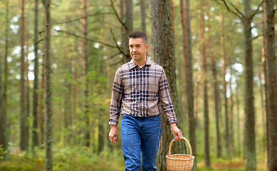 Image showing happy man with basket picking mushrooms in forest