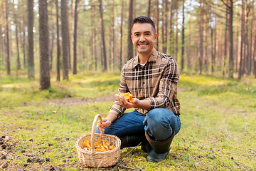 Image showing happy man with basket picking mushrooms in forest