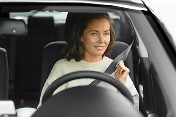 Image showing woman or female car driver fastening seat belt