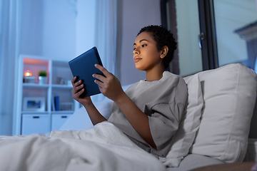 Image showing woman with tablet pc in bed at home at night