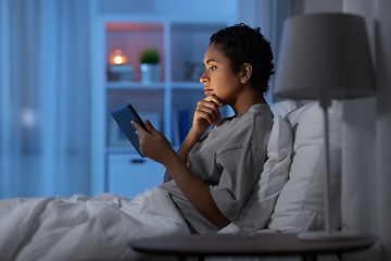 Image showing woman with tablet pc in bed at home at night