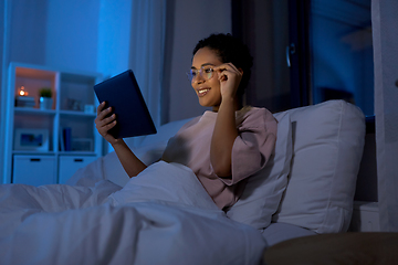 Image showing woman with tablet pc in bed at home at night