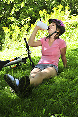 Image showing Teenage girl resting in a park with a bicycle