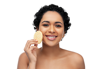 Image showing young woman cleaning face with exfoliating sponge