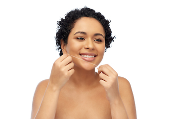 Image showing african woman cleaning teeth with dental floss