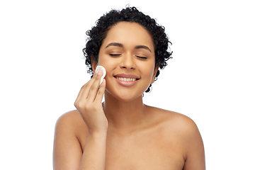 Image showing happy african woman cleaning face with cotton pad