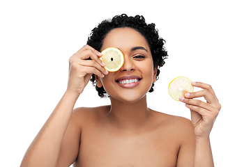 Image showing african american woman making eye mask of lemons