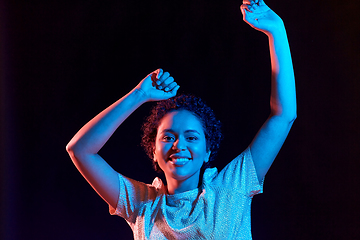 Image showing african american woman dancing over neon lights