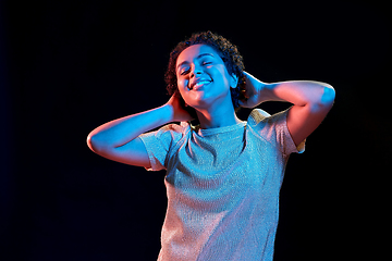 Image showing african american woman dancing over neon lights