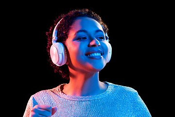 Image showing woman in headphones listening to music and dancing