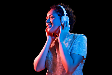 Image showing woman in headphones listening to music and dancing