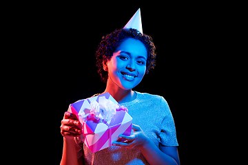 Image showing african woman in party cap with gift box on black