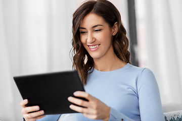 Image showing happy smiling young woman with tablet pc at home