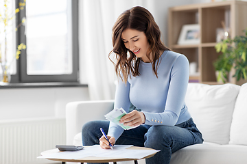 Image showing happy woman counting money at home