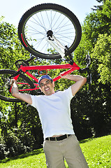 Image showing Man carrying a bicycle