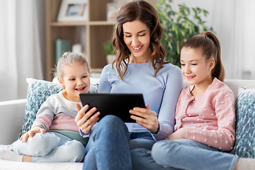 Image showing happy mother and daughters with tablet pc at home