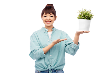 Image showing happy smiling asian woman holding flower in pot