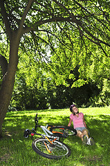 Image showing Teenage girl relaxing in a park with her bicycle