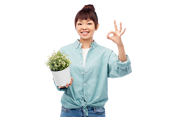 Image showing happy smiling asian woman holding flower in pot