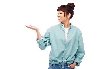 Image showing happy asian woman holding something on hand