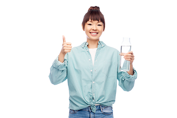 Image showing happy asian woman holding glass bottle with water