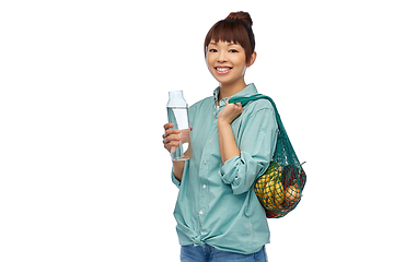 Image showing woman with food in string bag and glass bottle