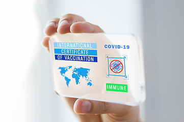 Image showing hand holding phone with certificate of vaccination