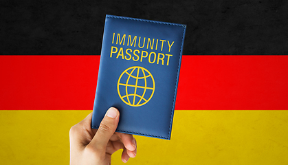 Image showing hand holding immunity passport over german flag