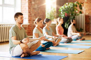 Image showing group of people making yoga exercises at studio