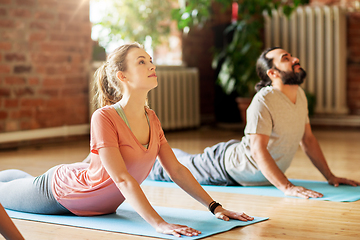 Image showing man and woman doing yoga cobra pose at studio