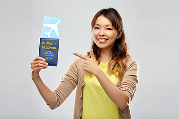 Image showing asian woman with air ticket and immunity passport