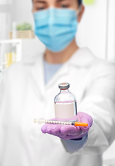 Image showing close up of doctor in mask with drug and syringe