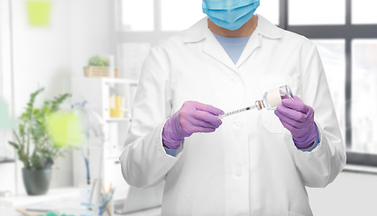 Image showing close up of doctor in mask with drug and syringe