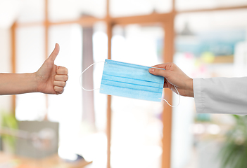 Image showing hand with mask and showing thumbs up at office