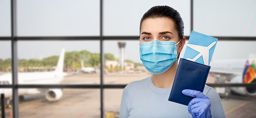 Image showing woman in mask with passport and ticket at airport