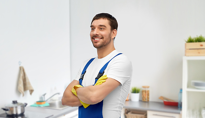 Image showing happy male worker or cleaner in gloves at kitchen