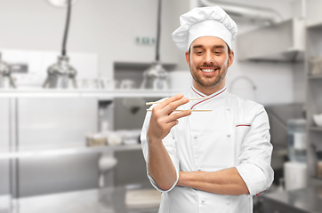 Image showing happy male chef with chopsticks at kitchen
